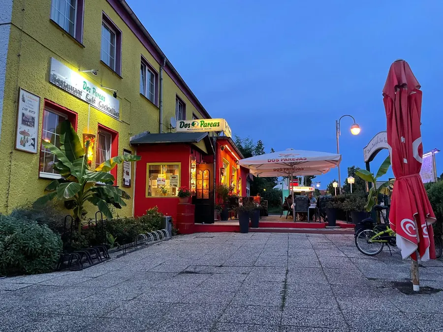 Parejas at dusk, with its terrace and warmly lit windows