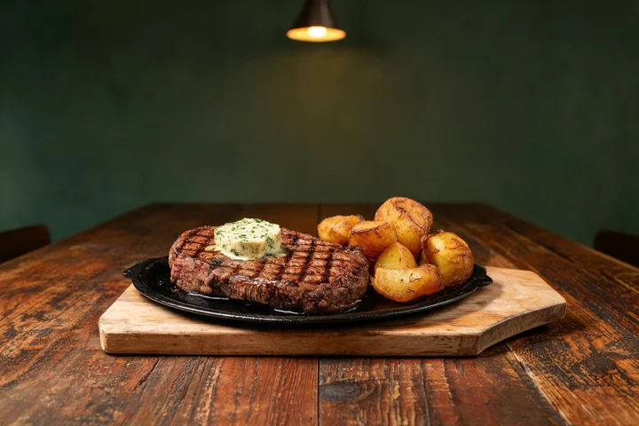 Grilled steak, sliced on a wooden board at Parejas Altlandsberg